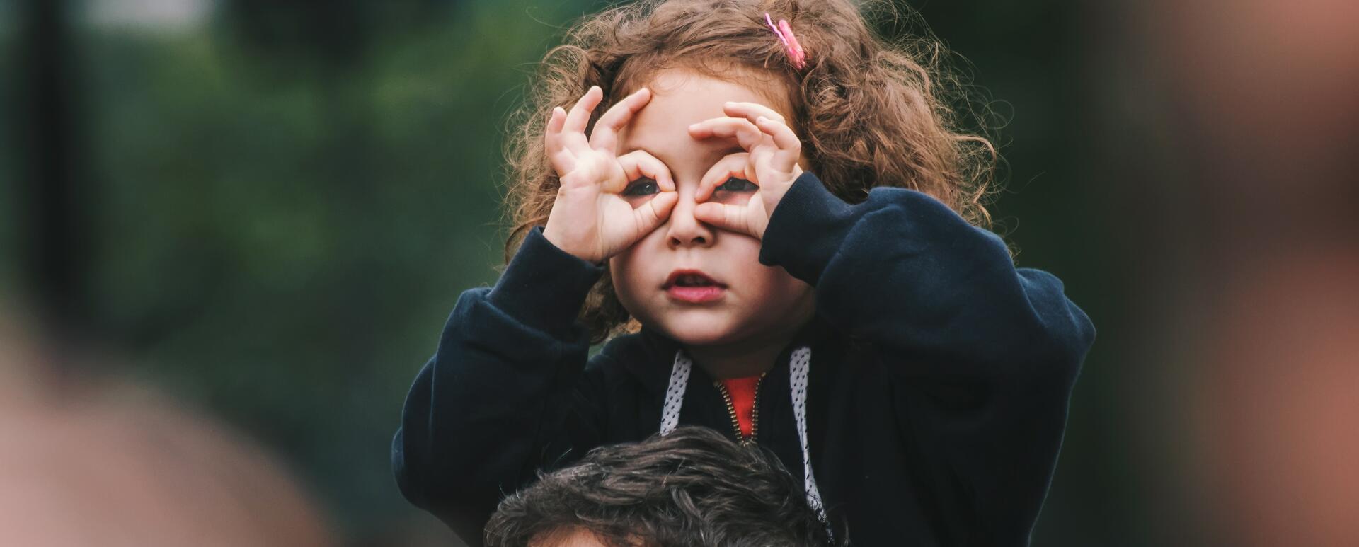 A girl making binocular gesture as in searching for something. Maybe she's looking for your drupal website in google?