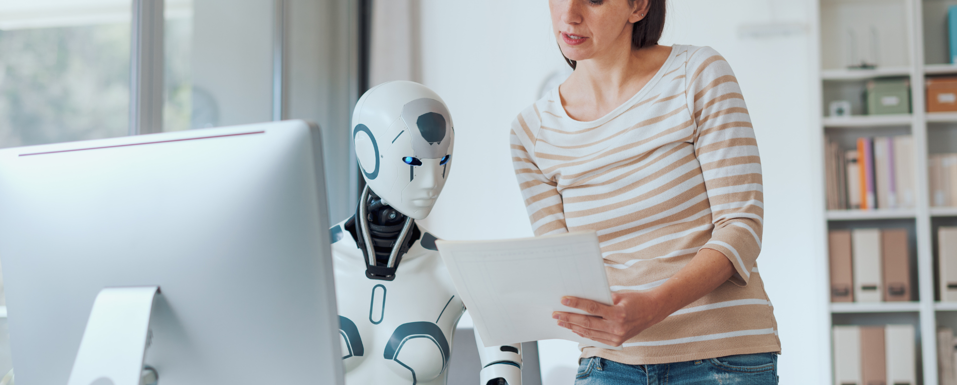 Rédactrice de contenu relit des pages imprimées avec un robot humanoïde au bureau - métaphore de la collaboration humain-IA pour du contenu answer-first.
