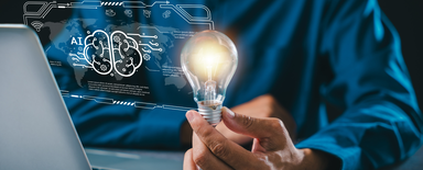 Personne devant un ordinateur portable tenant une ampoule lumineuse, avec un overlay holographique de cerveau IA - comment un contenu Drupal structuré aide les systèmes IA à lire et citer les pages web.