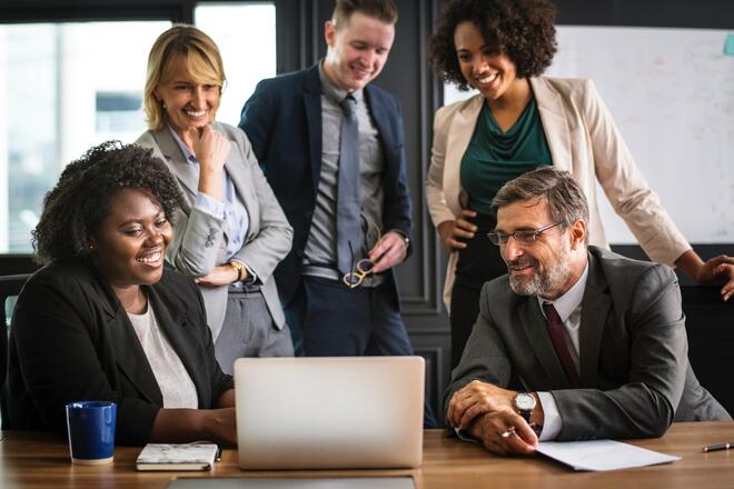 A diverse team of developers talks with pleased product owner