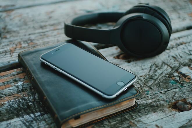 Phone, Bible and headphones on top of the desk.