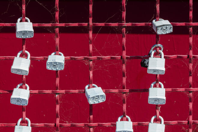 grey padlocks on the grey fence - symbol of security