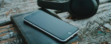 Phone, Bible and headphones on top of the desk.