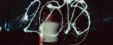 Fphoto made with long exposition. A man waves the sparkler to write "2018".