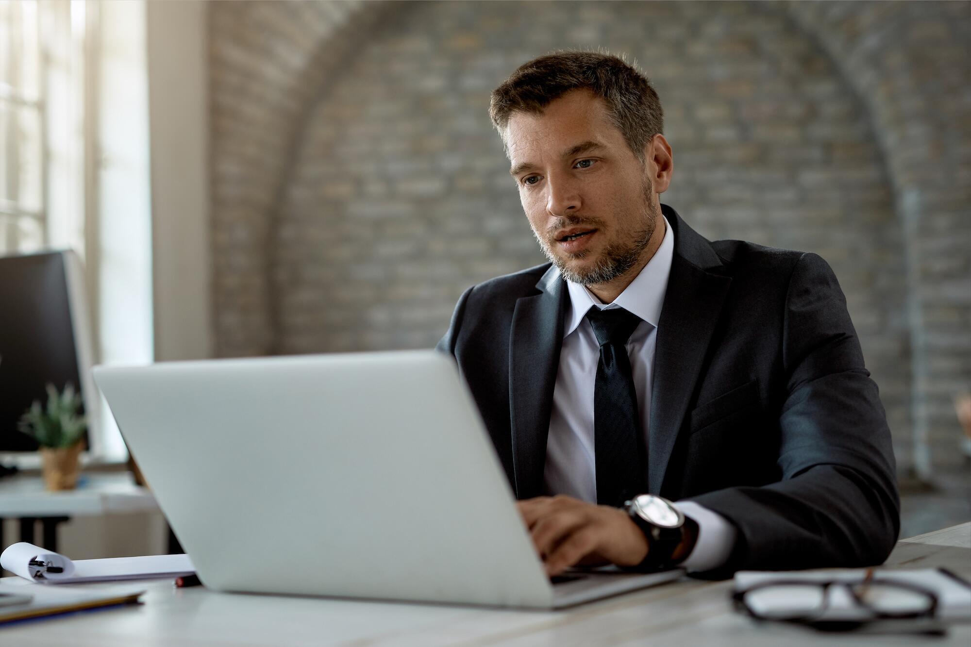 A legal professional sitting at a computer and reviewing content on the BetterRegulation platform.