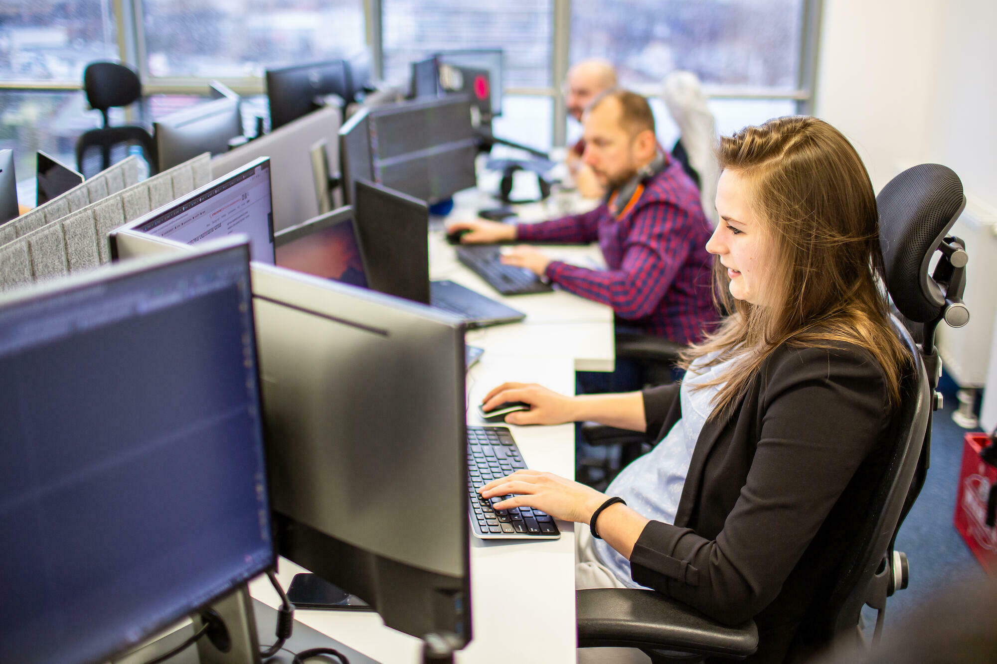 A specialist working at a computer in the office from Droptica's CMS and support team.
